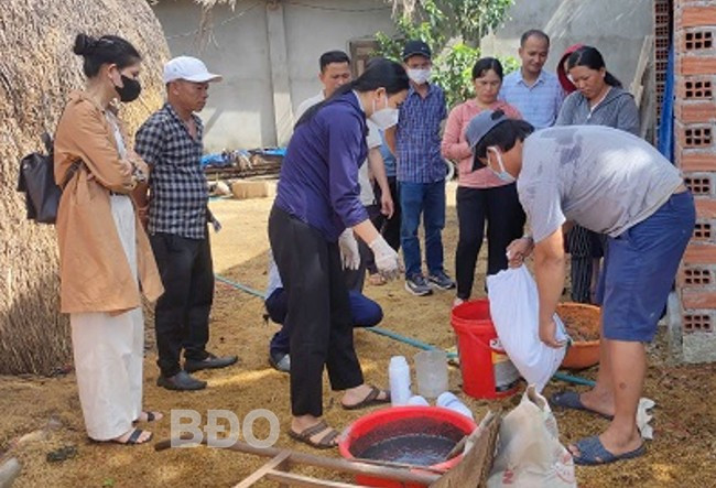 Hướng dẫn hộ dân sử dụng chế phẩm sinh học trong xử lý rác thải hữu cơ thành phân bón. Ảnh: THANH TRỌN