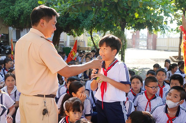 Học sinh Trường Tiểu học Hải Cảng, TP Quy Nhơn đặt câu hỏi về các tình huống tham gia giao thông an toàn tại buổi tuyên truyền về ATGT do Đội CSGT-TT (CA TP Quy Nhơn) phối hợp với Ban Giám hiệu nhà trường tổ chức ngày 30.9. Ảnh: N.LINH