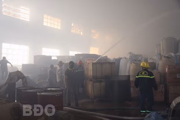 Phun nước dập lửa bên trong kho chứa nguyên liệu.