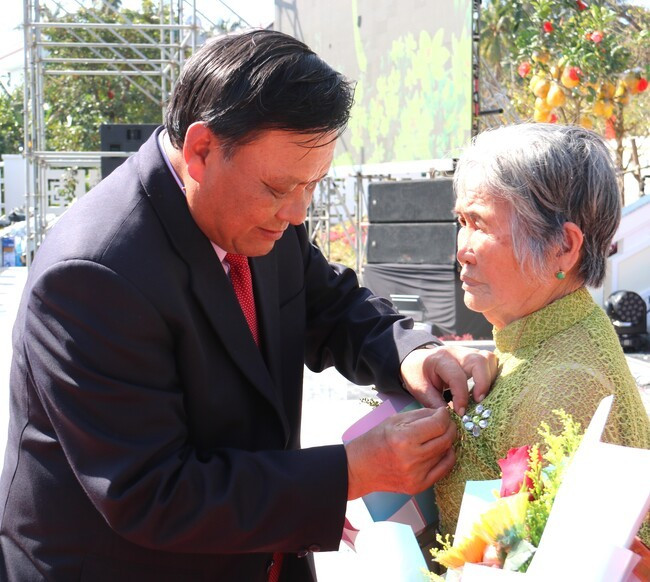 Phó Bí thư Thường trực Tỉnh ủy Lê Kim Toàn gắn Huy hiệu 60 năm tuổi Đảng cho đảng viên Nguyễn Thị Sàng (TX Hoài Nhơn). Ảnh: H.THU