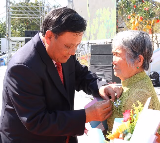 Phó Bí thư Thường trực Tỉnh ủy Lê Kim Toàn gắn Huy hiệu 60 năm tuổi Đảng cho đảng viên Nguyễn Thị Sàng (TX Hoài Nhơn). Ảnh: H.THU