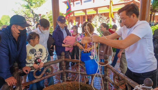 Tham quan giếng nước cổ. Ảnh: THANH NHÀN