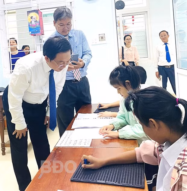 Một học sinh khiếm thị xung phong đọc bài cho Bí thư Tỉnh ủy nghe.