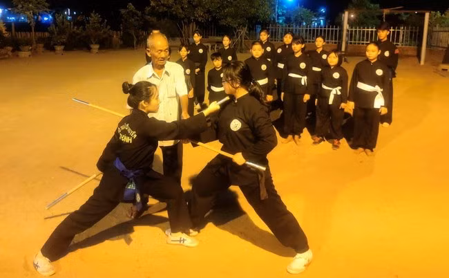 Đã gần 80 tuổi, đại võ sư Lê Xuân Cảnh vẫn dành thời gian theo dõi, hướng dẫn cho học trò tập luyện vào ban đêm tại sân tập nơi vườn nhà. Ảnh: Võ đường cung cấp