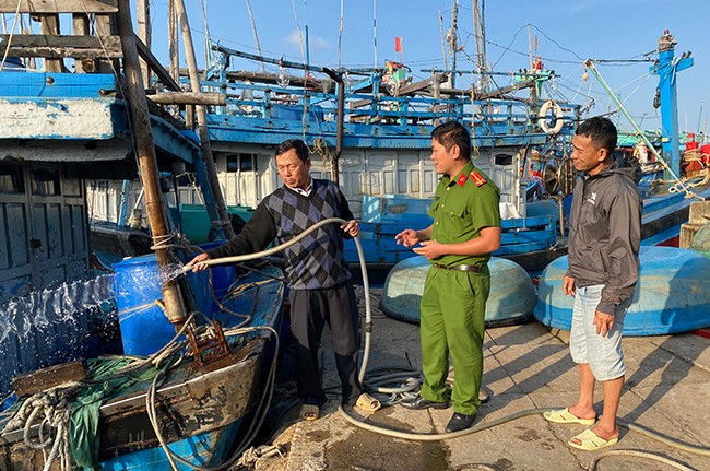 Ông Nguyễn Văn Dô (bìa trái) thường xuyên kiểm tra, bảo trì máy bơm để phục vụ hoạt động chữa cháy tại chỗ khi xảy ra hỏa hoạn trên tàu cá. Ảnh: N.C