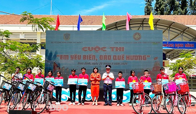 Lãnh đạo Bộ Tư lệnh Vùng Cảnh sát biển 2, Ban Tuyên giáo và Dân vận Tỉnh ủy tặng biểu trưng hỗ trợ xe đạp cho các học sinh. Ảnh: D.Đ