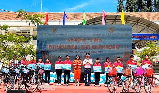 Lãnh đạo Bộ Tư lệnh Vùng Cảnh sát biển 2, Ban Tuyên giáo và Dân vận Tỉnh ủy tặng biểu trưng hỗ trợ xe đạp cho các học sinh. Ảnh: D.Đ