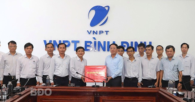 Chủ tịch UBND tỉnh Phạm Anh Tuấn (hàng trên, thứ 4 từ phải sang) tặng quà động viên cán bộ, nhân viên VNPT Bình Định. Ảnh: M.H