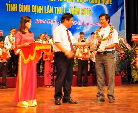 Bí thư Tỉnh ủy Nguyễn Thanh Tùng (đứng giữa) trao Cúp vinh danh trí thức tiêu biểu về Khoa học - Công nghệ tỉnh Bình Định lần thứ Nhất, năm 2016, cho Thạc sĩ Lê Ngọc Vịnh.