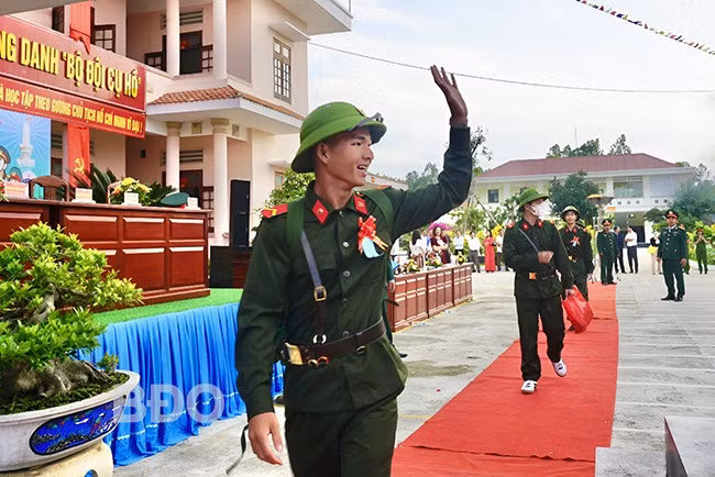 Thanh niên huyện Tuy Phước vẫy tay chào người thân trên đường tòng quân. Ảnh: T.K