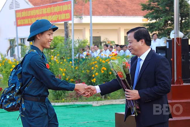 Đồng chí Nguyễn Tuấn Thanh, Phó Chủ tịch Thường trực UBND tỉnh tặng hoa, chúc mừng các tân binh lên đường nhập ngũ. Ảnh: N.M