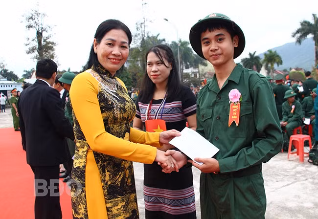 Phó Chủ tịch HĐND tỉnh Huỳnh Thúy Vân cài hoa và tặng quà cho thanh niên lên đường nhập ngũ. Ảnh: C.H