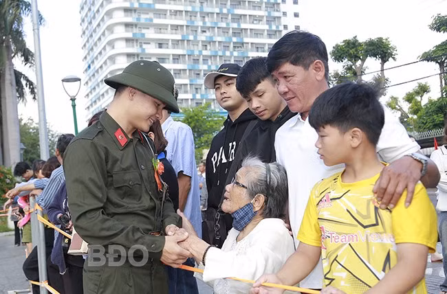 TN Trần Hữu Long lưu luyến chia tay bà và gia đình để lên đường nhập ngũ. Ảnh: HỒNG PHÚC