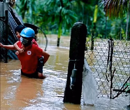 Chị Thủy cõng em Bảo từ ngôi nhà bị ngập sâu đến nơi an toàn vào ngày 29.11. Ảnh: Hội CTĐ huyện Hoài Ân