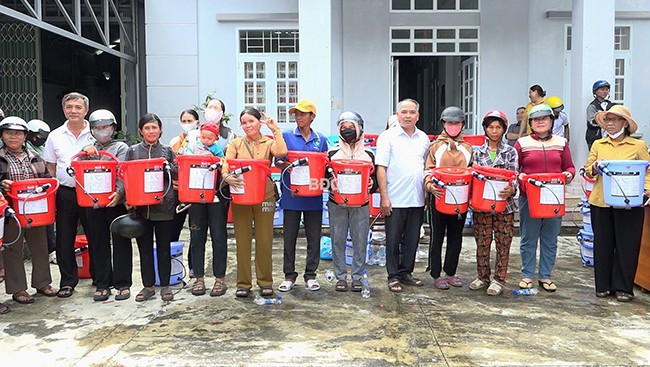 Lãnh đạo Hội CTĐ tỉnh và huyện trao bộ lọc nước cho các hộ dân. Ảnh: Xuân Dũng