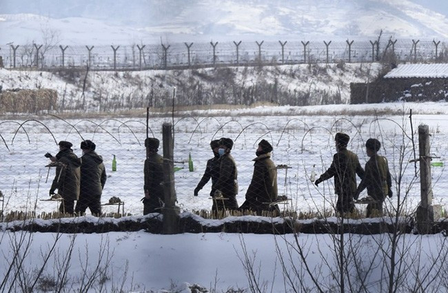Binh lính Triều Tiên tuần tra trên bờ sông dọc theo hàng rào kiên cố ở huyện biên giới Uiju, tỉnh Bắc Pyongan - Ảnh: KYODO NEWS
