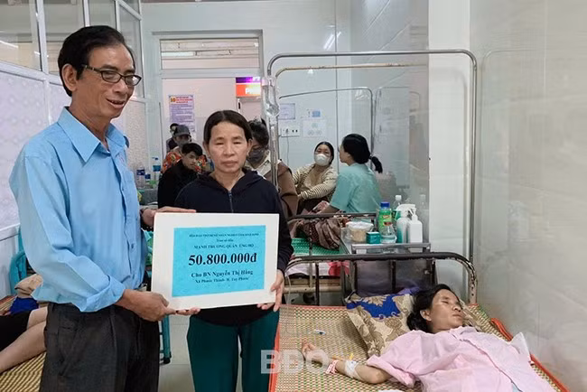 Đại diện Hội Bảo trợ Bệnh nhân nghèo tỉnh trao tiền cho người nhà bệnh nhân Nguyễn Thị Hằng. Ảnh: ĐVCC.