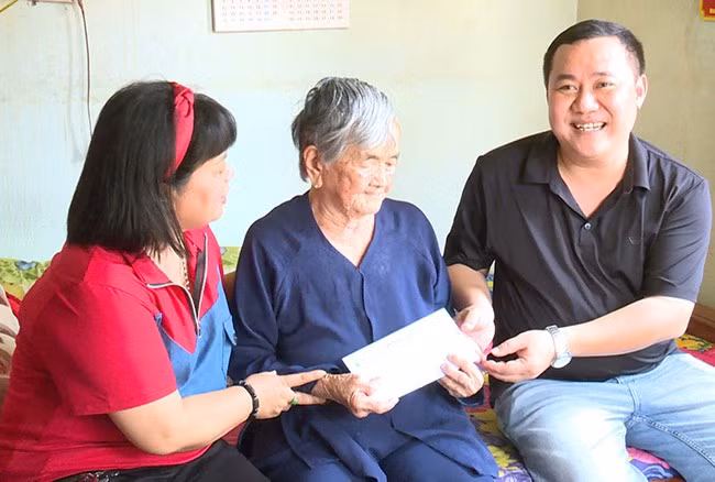 Trao tiền phụng dưỡng cho mẹ Việt Nam anh hùng Nguyễn Thị Nhiễu (xã Tây Giang). Ảnh: V.P