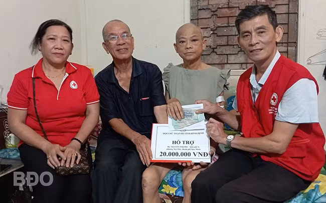 Ông Lê Phong, Phó Chủ tịch thường trực Hội CTĐ tỉnh (bìa phải) trao tiền hỗ trợ cho bà Nguyễn Thị Phu.