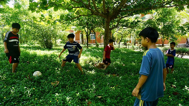 Các bé trai chơi trò chuyền bóng sau khi phụ mẹ việc nhà. Ảnh: T.K Các bé trai chơi trò chuyền bóng sau khi phụ mẹ việc nhà. Ảnh: T.K