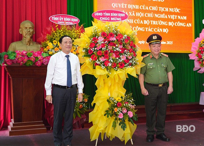 Chủ tịch UBND tỉnh Phạm Anh Tuấn tặng hoa chúc mừng thiếu tướng Lê Quang Nhân. Ảnh: M.N