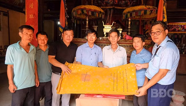 Nhóm nghiên cứu tiếp cận các sắc phong đang được lưu giữ tại chùa An Hòa. Ảnh: NGỌC NHUẬN Nhóm nghiên cứu tiếp cận các sắc phong đang được lưu giữ tại chùa An Hòa. Ảnh: NGỌC NHUẬN