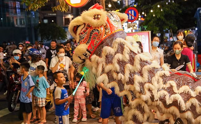 Các em nhỏ thích thú chọc ghẹo chú lân đầy màu sắc