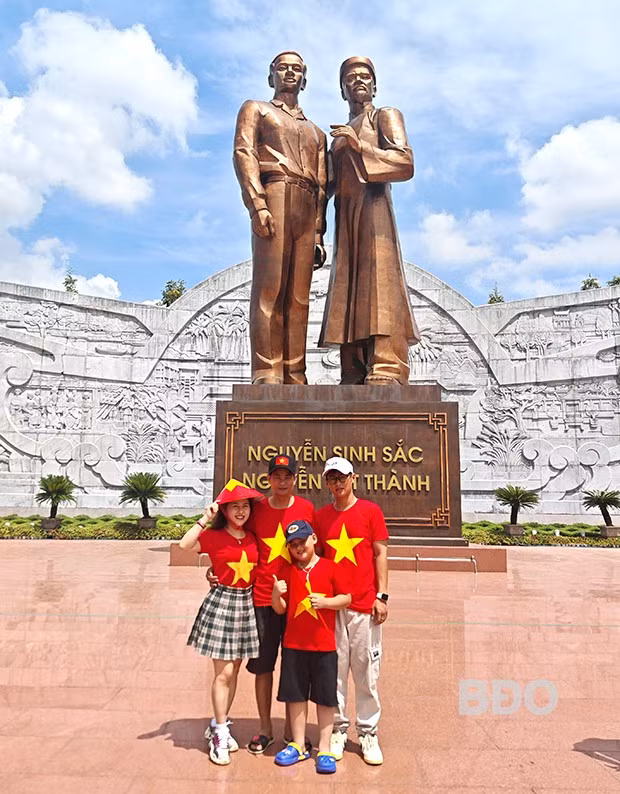 Gia đình anh Trần Đăng Khoa chụp ảnh lưu niệm tại Tượng đài. Ảnh: H.THU