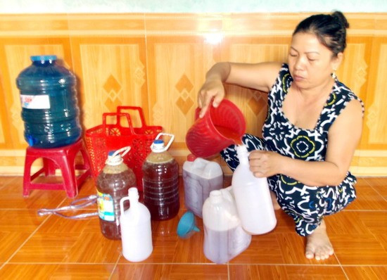 Chị Đinh Thị Thao đang sang chiết mật ong rừng thành từng lít. Ảnh: H.N.Q Chị Đinh Thị Thao đang sang chiết mật ong rừng thành từng lít. Ảnh: H.N.Q