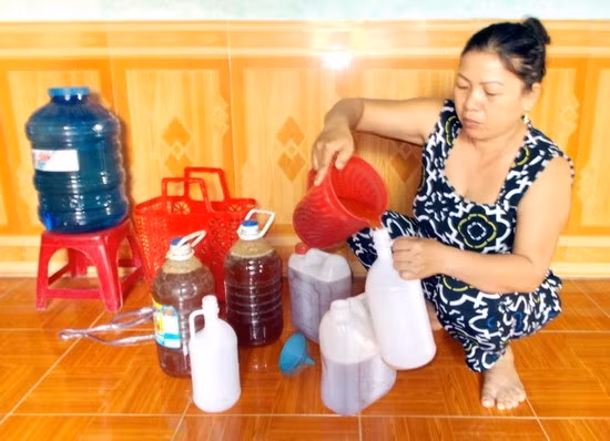 Chị Đinh Thị Thao đang sang chiết mật ong rừng thành từng lít. Ảnh: H.N.Q