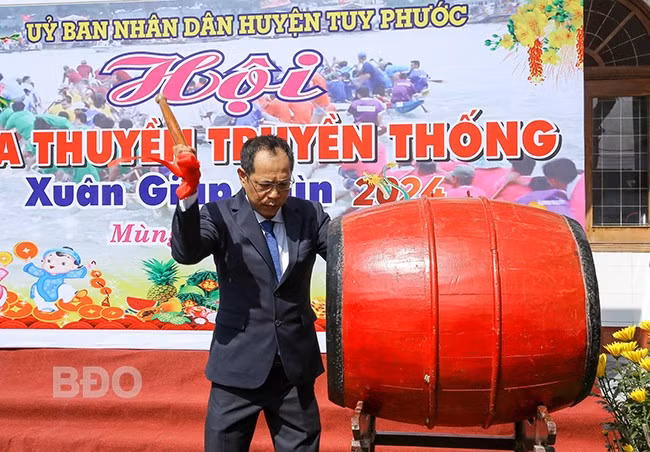 Ông Nguyễn Hùng Tân, Phó Chủ tịch UBND huyện Tuy Phước đánh trống khai mạc Lễ hội đua thuyền trên sông Gò Bồi chiều mùng 2 Tết. Ảnh: N.DŨNG