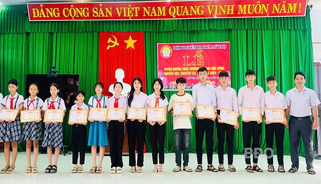 Lãnh đạo UBND xã Mỹ Thọ trao giấy khen và học bổng cho học sinh. Ảnh: ĐVCC