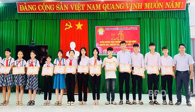 Lãnh đạo UBND xã Mỹ Thọ trao giấy khen và học bổng cho học sinh. Ảnh: ĐVCC
