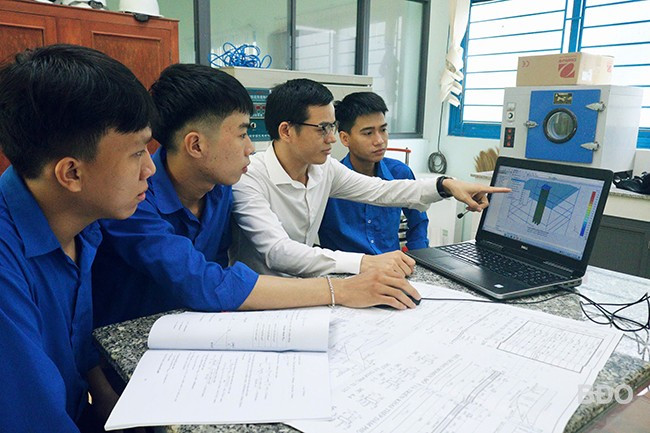 Ths. Hoàng Công Vũ (áo trắng) cùng nhóm sinh viên ngành Kỹ thuật xây dựng trao đổi về các mô hình NCKH. Ảnh. NVCC