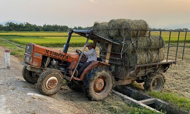 Xe máy cày gắn rơ moóc băng qua mương thủy lợi để leo lên đường giao thông ở thôn Tân Kiều (xã Nhơn Mỹ, TX An Nhơn). Ảnh: N.C