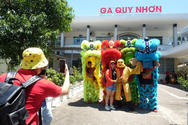 Du khách thích thú chụp ảnh lưu niệm tại ga Quy Nhơn khi vừa xuống tàu được chào đón nồng hậu. Ảnh: ĐOAN NGỌC Du khách thích thú chụp ảnh lưu niệm tại ga Quy Nhơn khi vừa xuống tàu được chào đón nồng hậu. Ảnh: ĐOAN NGỌC