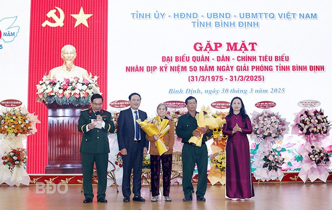 Chủ tịch UBND tỉnh Phạm Anh Tuấn và Chủ tịch Ủy ban MTTQ Việt Nam tỉnh Lê Bình Thanh tặng hoa cho CCB Võ Lụa và bà Lê Thị Hoa. Ảnh: H.P