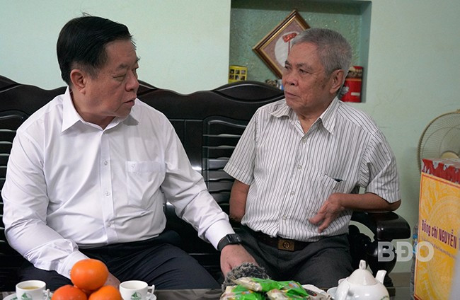 Đồng chí Nguyễn Trọng Nghĩa (bên trái) thăm hỏi cuộc sống gia đình thương binh Lê Văn Thấn. Ảnh: N. HÂN