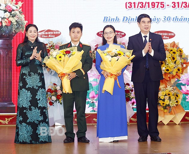 Phó Chủ tịch HĐND tỉnh Huỳnh Thúy Vân và Phó Chủ tịch UBND tỉnh Lâm Hải Giang tặng hoa cho thượng úy Nguyễn Chu Khánh và tiến sĩ Lê Mộng Huyền. Ảnh: H.P