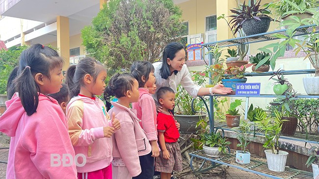 Cô giáo Trường Mầm non thị trấn Vân Canh (huyện Vân Canh) hướng dẫn cho trẻ người dân tộc thiểu số tìm hiểu các loài cây ở sân trường qua góc song ngữ. Ảnh: HỒ ĐIỂM Cô giáo Trường Mầm non thị trấn Vân Canh (huyện Vân Canh) hướng dẫn cho trẻ người dân tộc thiểu số tìm hiểu các loài cây ở sân trường qua góc song ngữ. Ảnh: HỒ ĐIỂM