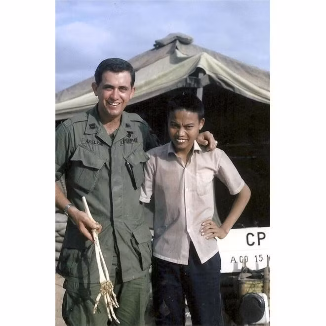 Bức ảnh được chụp năm 1967, bác sĩ Sam Axelrad cầm đoạn xương tay đã cắt bên cạnh anh lính Nguyễn Quang Hùng. Ảnh: AP