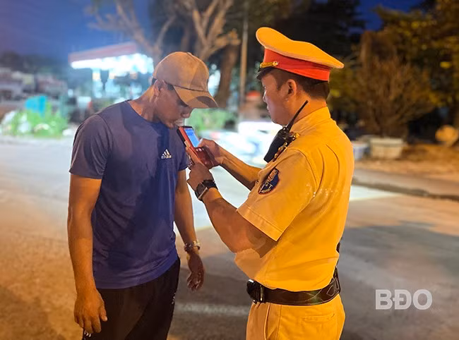 Tổ CSGT Trạm CSGT Tuy Phước kiểm tra nồng độ cồn đối với lái xe trên tuyến QL1 đoạn qua địa bàn xã Phước Lộc (huyện Tuy Phước). Ảnh: Q.T