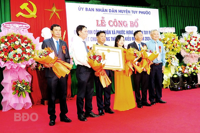 Thừa ủy quyền UBND tỉnh, UBND huyện Tuy Phước trao Quyết định công nhận xã Phước Hưng đạt chuẩn NTM kiểu mẫu. Ảnh: Xuân Thức.