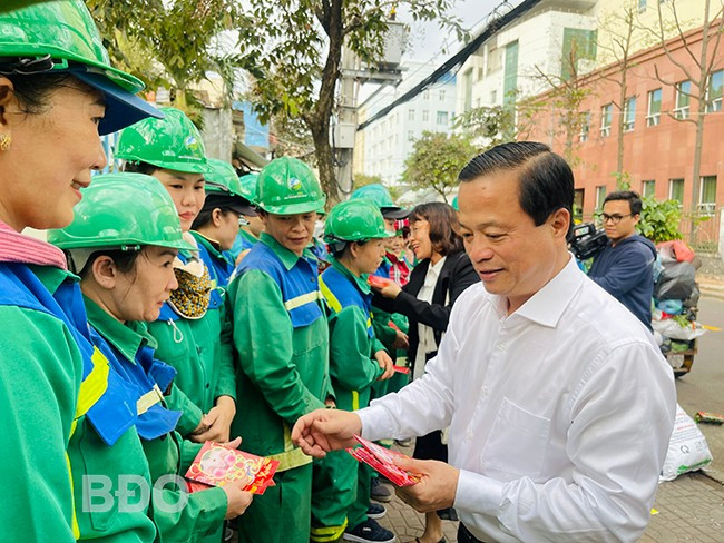Phó Chủ tịch Thường trực UBND tỉnh Nguyễn Tuấn Thanh (bìa phải) tặng quà cho công nhân đang làm việc tại đường Diên Hồng (TP Quy Nhơn). Ảnh: HẢI YẾN