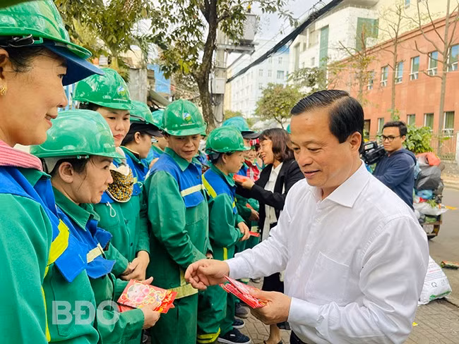 Phó Chủ tịch Thường trực UBND tỉnh Nguyễn Tuấn Thanh (bìa phải) tặng quà cho công nhân đang làm việc tại đường Diên Hồng (TP Quy Nhơn). Ảnh: HẢI YẾN