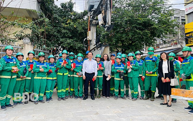 Phó Chủ tịch Thường trực UBND tỉnh Nguyễn Tuấn Thanh (đứng hàng trên cùng) tặng quà cho công nhân đang làm việc tại đường Ỷ Lan (TP Quy Nhơn). Ảnh: HẢI YẾN