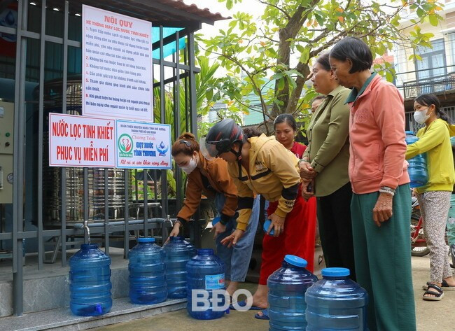 Người dân xã Phước Quang (huyện Tuy Phước) xếp hàng chờ lấy nước sạch về sử dụng. Ảnh: TÀI NGÂN