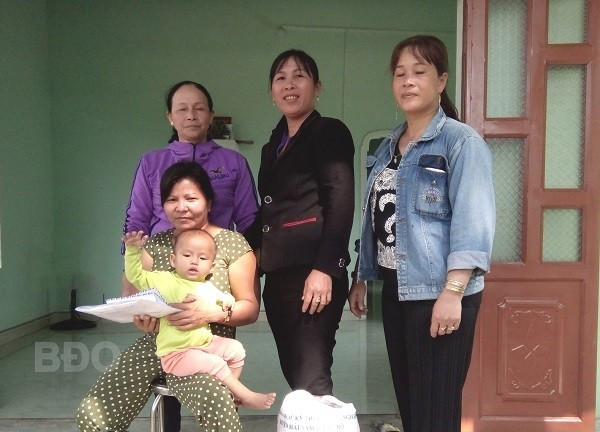 Phụ nữ khu phố Hội Phú trao số tiền vận động hỗ trợ xây nhà và số gạo phụ nữ bỏ hũ tặng chị Nguyễn Thị Á (ngồi).