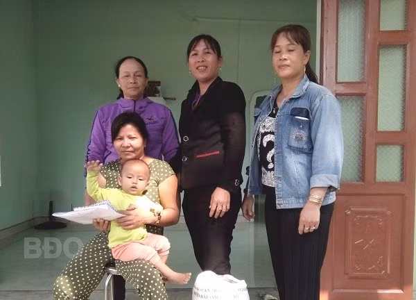 Phụ nữ khu phố Hội Phú trao số tiền vận động hỗ trợ xây nhà và số gạo phụ nữ bỏ hũ tặng chị Nguyễn Thị Á (ngồi).