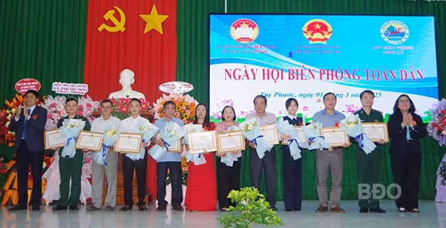 Lãnh đạo Huyện ủy, UBND huyện Tuy Phước tặng giấy khen cho các tập thể, cá nhân có thành tích tốt trong thực hiện Chỉ thị số 01 ngày 9/1/2015 của Thủ tướng Chính phủ về thực hiện Phong trào “Toàn dân tham gia bảo vệ chủ quyền lãnh thổ, an ninh biên giới quốc gia trong tình hình mới”. Ảnh: CÔNG CƯỜNG